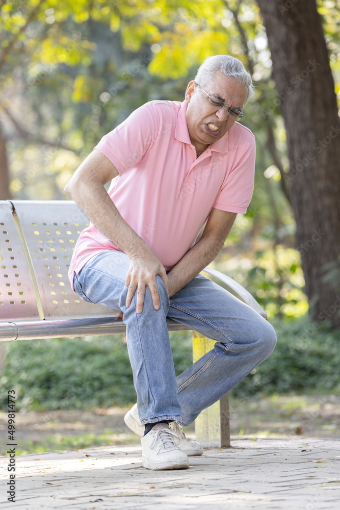 Senior man suffering from knee pain at park Senior man suffering from knee pain at park