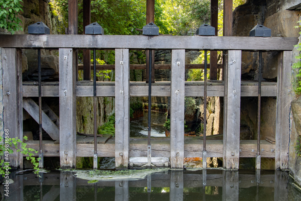 The regulated sluice on a water canal with flowing water The regulated sluice on a water canal with flowing water