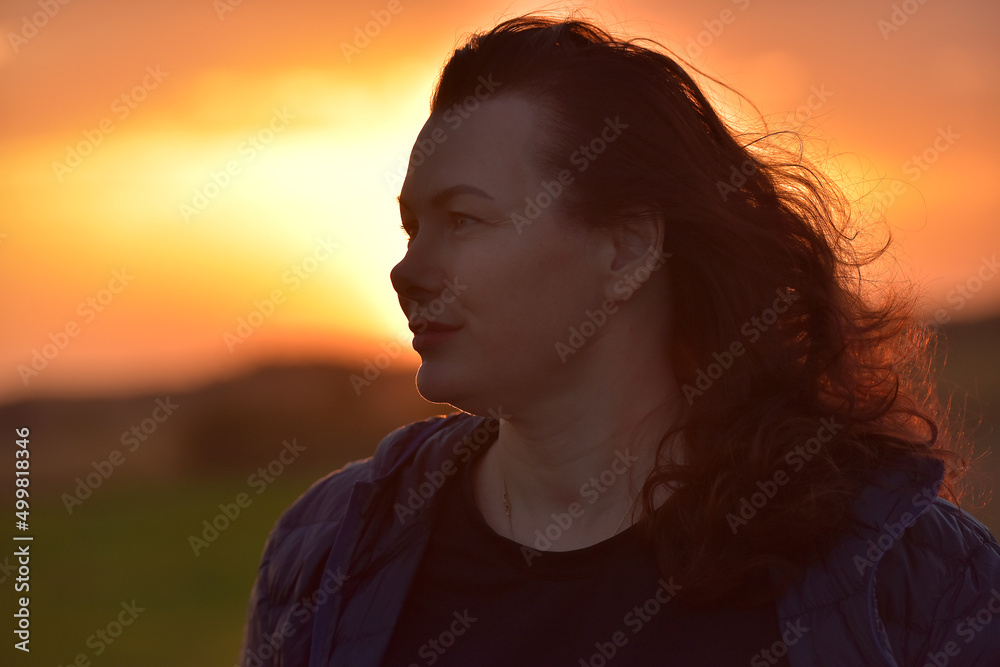 portrait of a red-haired woman in the evening against a sunset portrait of a red-haired woman in the evening against a sunset