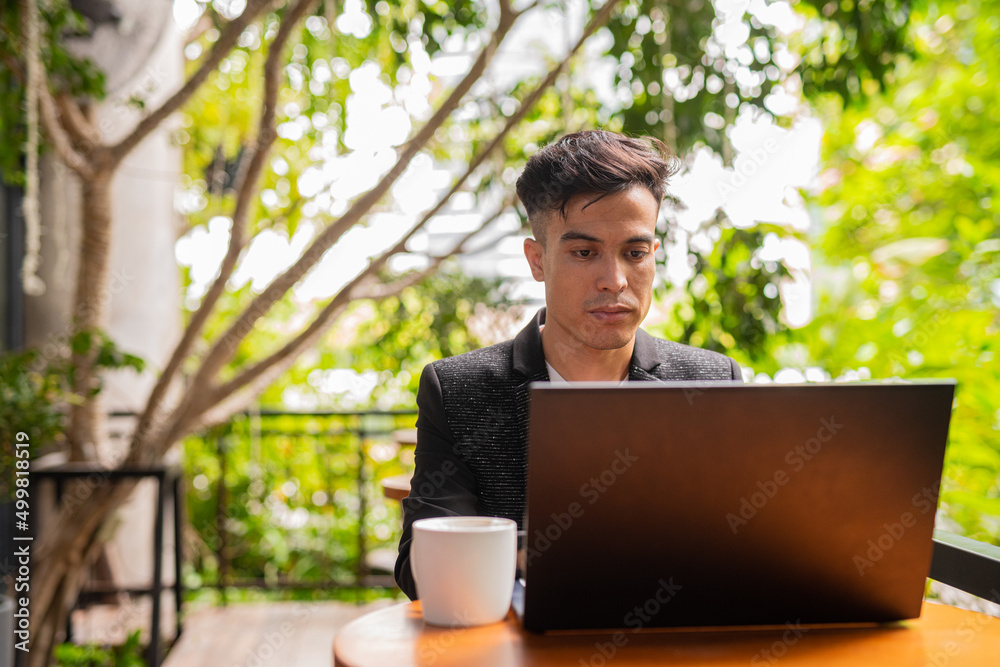 Portrait of handsome young businessman using laptop in coffee shop Portrait of handsome young businessman using laptop in coffee shop