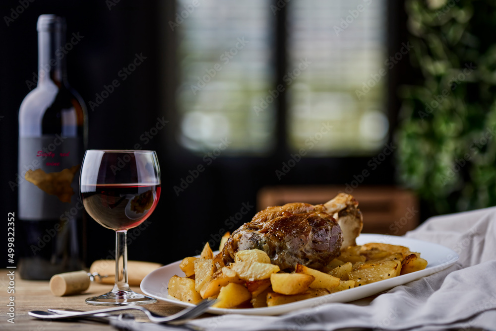Pork shank with baked potatoes and Sicilian red wine Pork shank with baked potatoes and Sicilian red wine