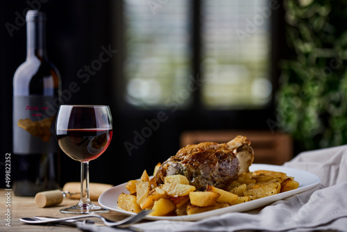 Pork shank with baked potatoes and Sicilian red wine photo