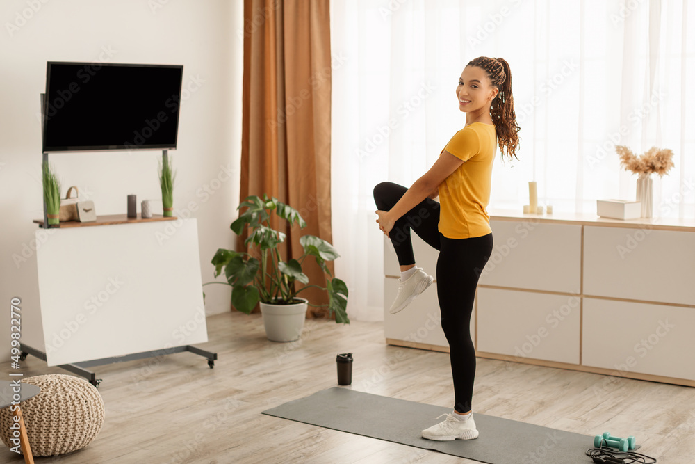 African American Fitness Female Stretching Leg Exercising Standing At Home African American Fitness Female Stretching Leg Exercising Standing At Home