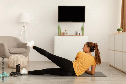 Black Female Doing Side Leg Raises Lying Training At Home