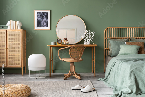 Foto Stylish composition of bedroom in modern glamour interior design with vanity table, big rounded mirror, tropical bed and beautiful personal accessories