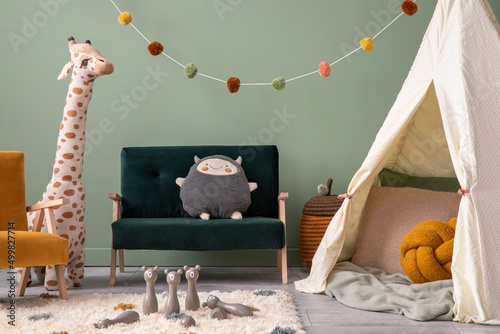 Creative composition of stylish and cozy child room interior design with greeen wall, plush toys, hut, furniture and accessories. Panels floor. Template.. photo