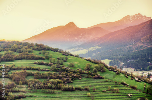 Morning yellow light over countryside with hills at background