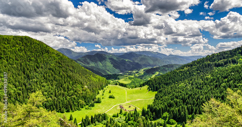 Beautiful mountain and forest landscape. White clouds on blue sky photo