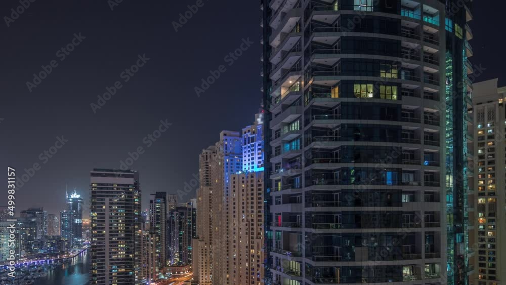 Overview to JBR and Dubai Marina skyline with modern high rise skyscrapers waterfront living apartments aerial night timelapse