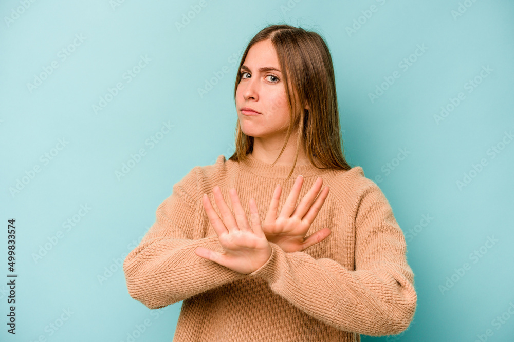 Young caucasian woman isolated on blue background doing a denial gesture