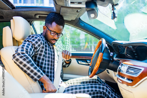 brazilian man fastening seat belt in car and ready to move photo