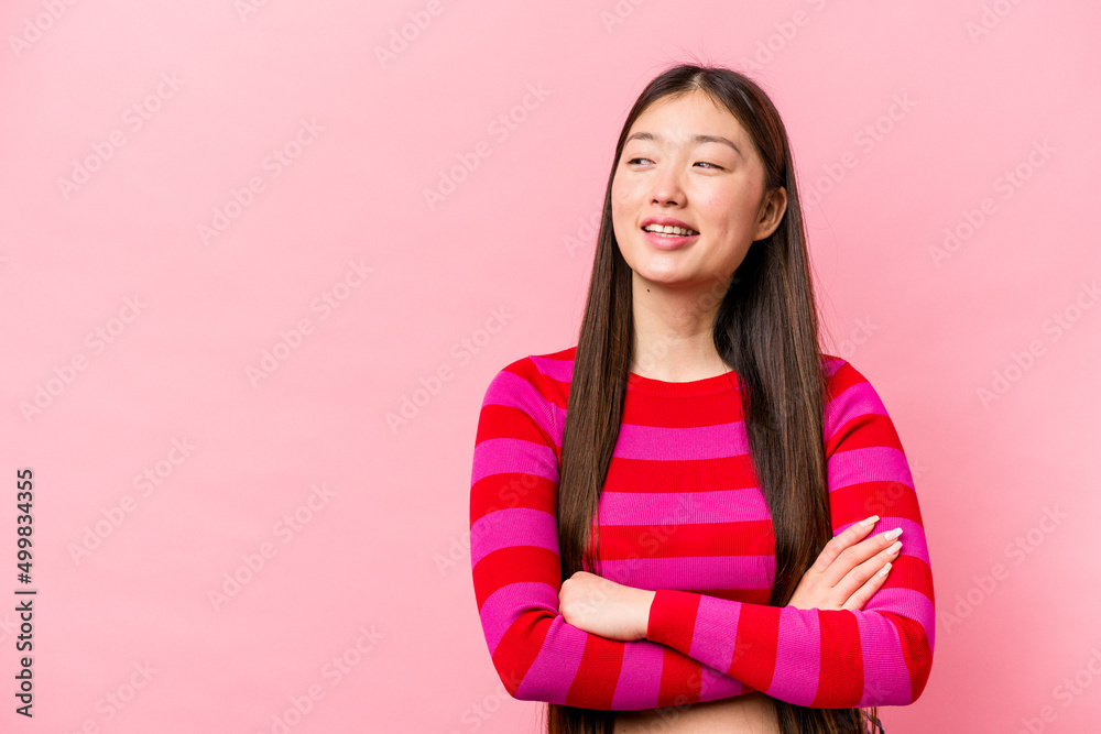 Young Chinese woman isolated on pink background smiling confident with crossed arms.