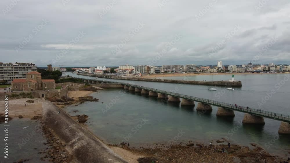Aerial drone flying over Saint Nicolas church toward Sables d'Olonne city from Grande Jetée long pier Aerial drone flying over Saint Nicolas church toward Sables d'Olonne city from Grande Jetée long pier