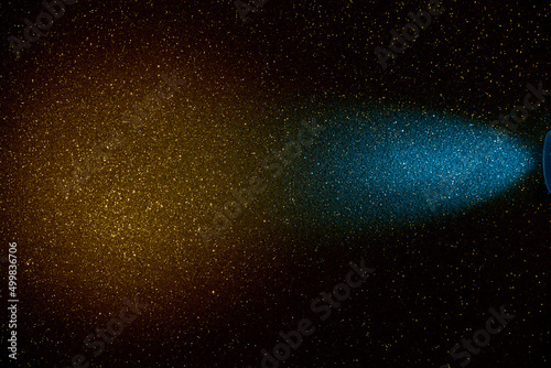 On a dark yellow gradient background in a finely grained light blue beam of light