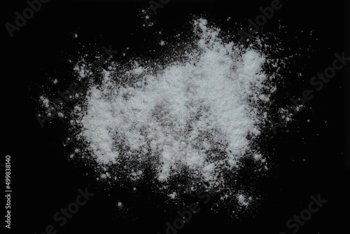 Black background sprinkled with flour, smeared flour, table for cooking, rolling dough. Preparing for baking, top view isolated on a black background or table.