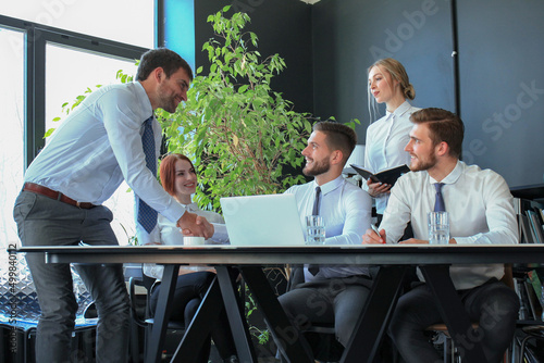 Businessman shaking hands to seal a deal with his partner and colleagues in office.
