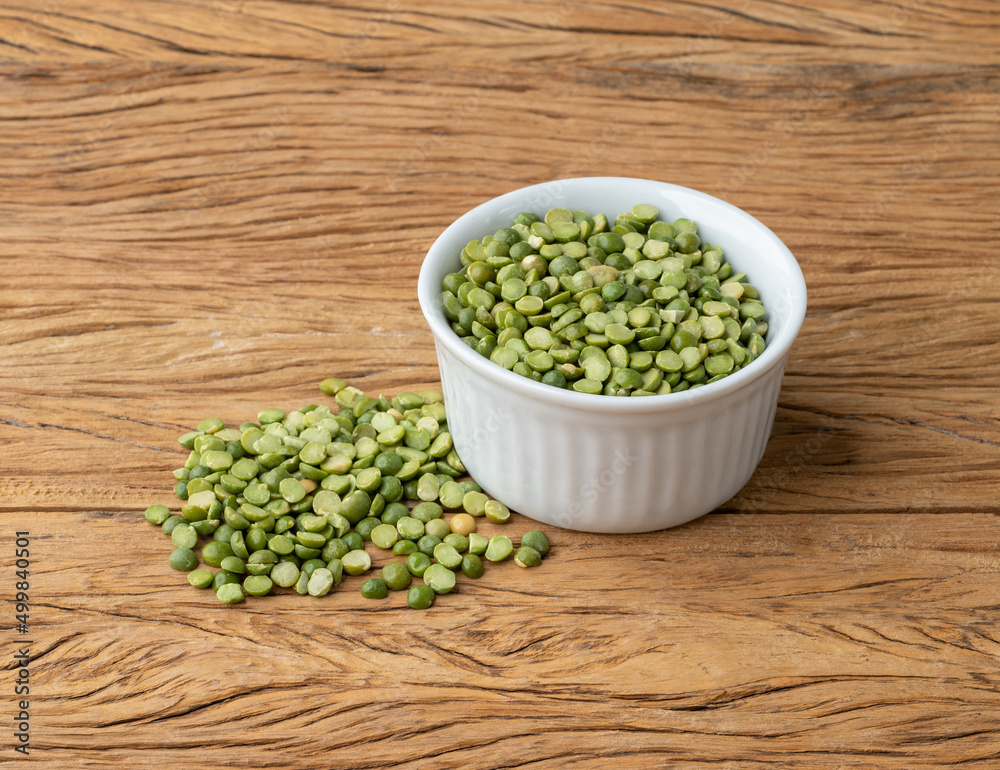 Raw dried green peas in a bowl over wooden table Raw dried green peas in a bowl over wooden table