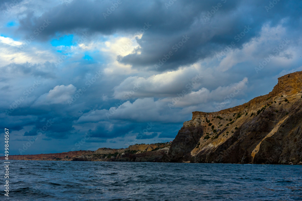 rocks of Cape Fiolent against the background of the evening sky with clouds