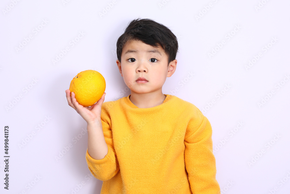 みかん(甘夏)を持っている元気な男の子。服も黄色い。 みかん(甘夏)を持っている元気な男の子。服も黄色い。