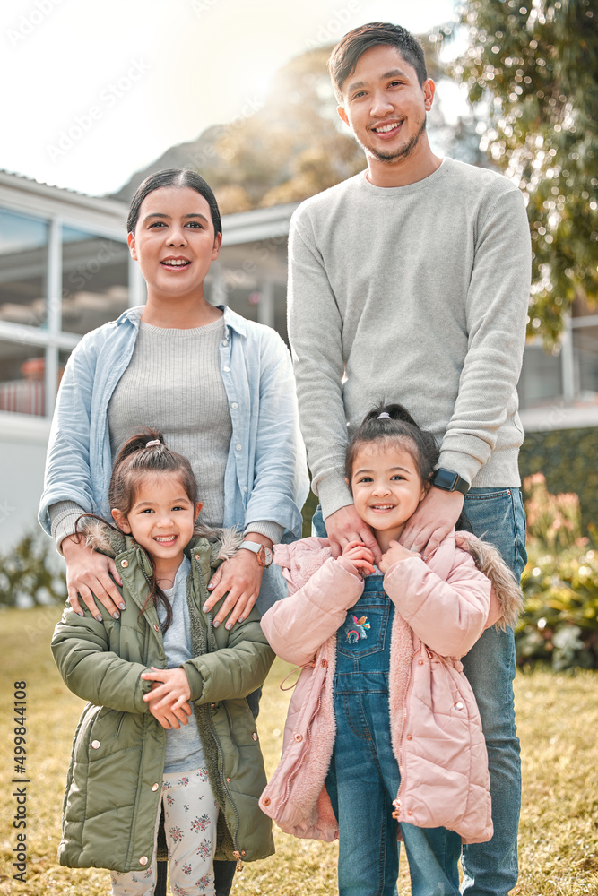 This is my beautiful family. Shot of a young couple and their two daughters standing outside their home. This is my beautiful family. Shot of a young couple and their two daughters standing outside their home.