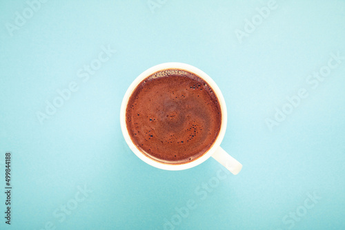 A cup of fresh hot Turkish coffee on blue background.