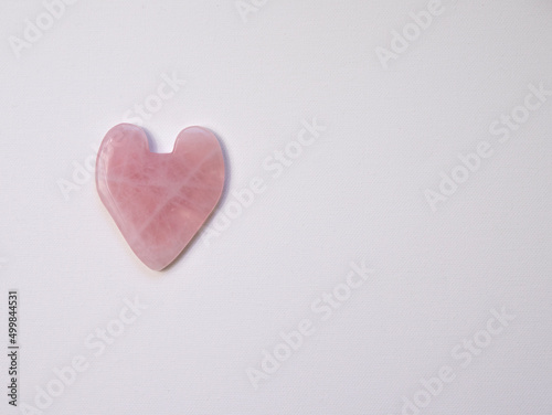 pink heart stone guasha face massage on white background isolate