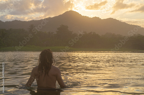 Man from behind with long hair in the lake © Roger