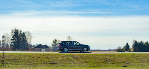 Black new sport crossover driving on the highway in sunny day