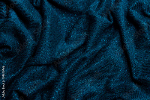 Smooth shiny fabric texture with folds and waves. Close up silk background