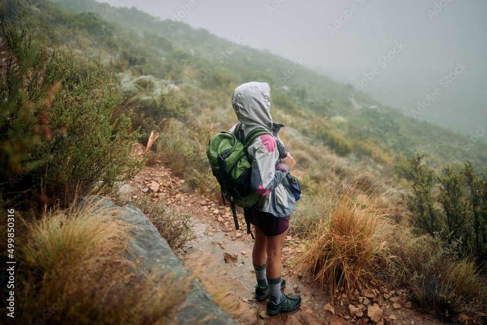 Come rain or sunshine, I always make time for hiking. Shot of a woman wearing her rain jacket while out hiking.
