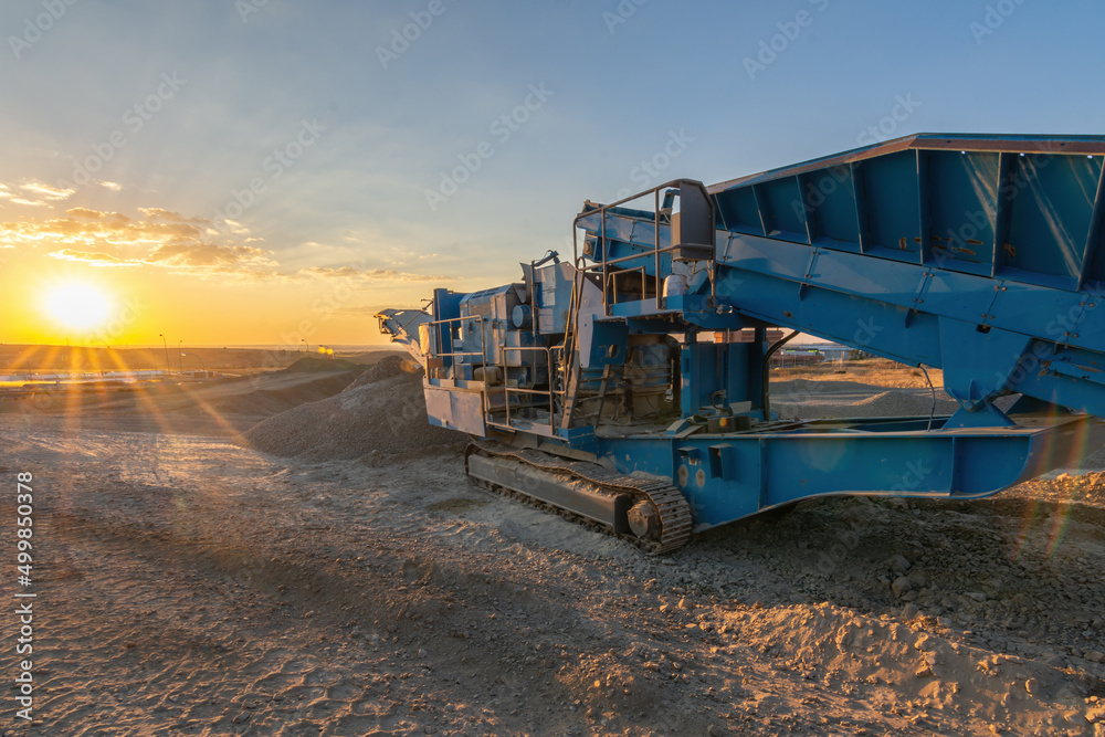 Heavy and mobile machinery in a quarry to transform stone into construction material Heavy and mobile machinery in a quarry to transform stone into construction material