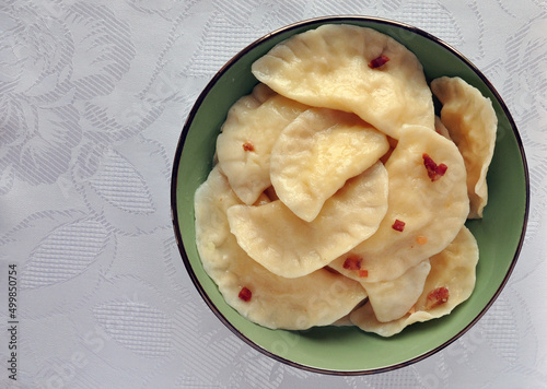 Ukrainain national food made with dough, vareniky with cracklings on the green bow, top view photo