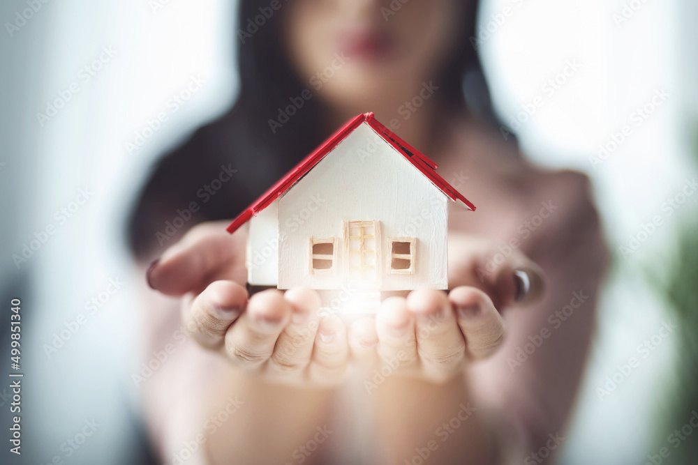 real estate agents, An employee of a real estate agent is presenting a model house to the customer. real estate agents, An employee of a real estate agent is presenting a model house to the customer.