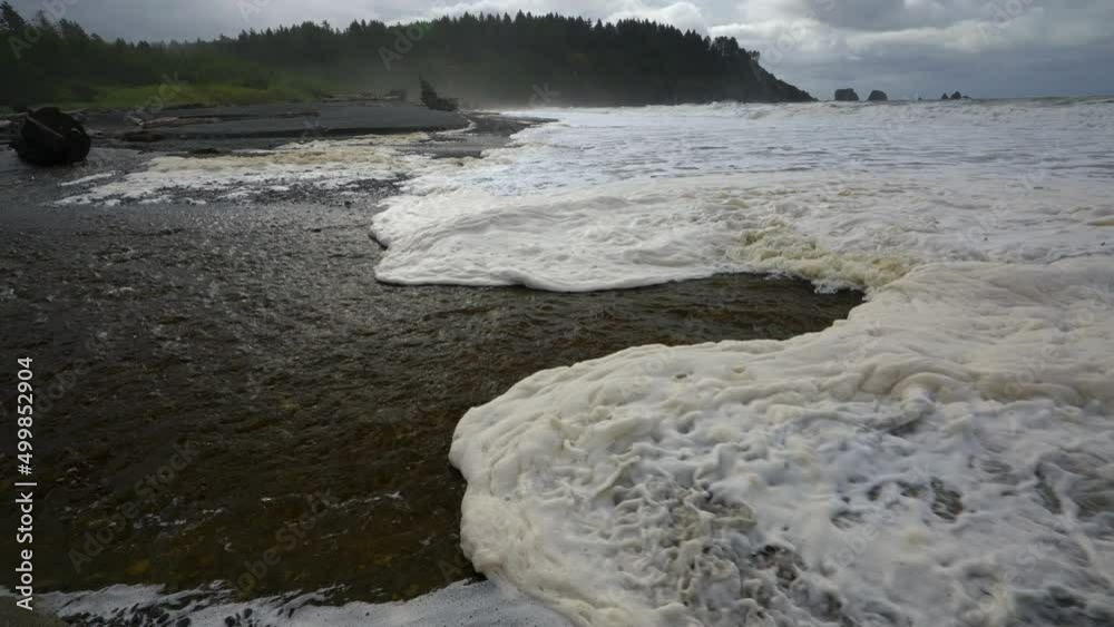 White Foamy Waves Rolling Onto Shoreline On A Stormy Day. Slow Motion White Foamy Waves Rolling Onto Shoreline On A Stormy Day. Slow Motion