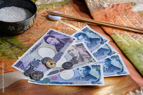 Foto Coins and paper banknotes of Japanese yen on the background of national fabric w
