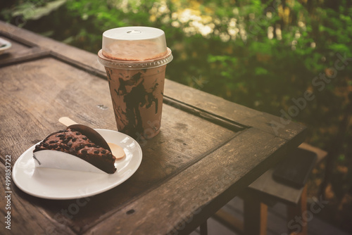 Ice Mocca on wood table , Coffee cup plastic under sunshine morning .