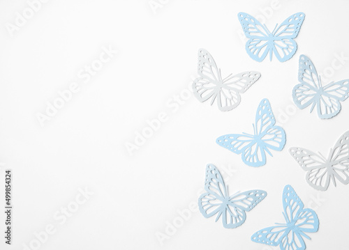 Pastel Blue Butterflies on a White Background. Simple Modern Composition with Paper Cut Butterfies ideal for Banner, Card, Greetings. Top-Down View. No text.