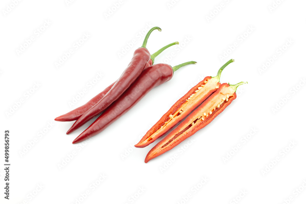 Pile of three fresh raw ripe hot organic red chili peppers whole and one of chilli pepper cut half isolated on white background clipping path Pile of three fresh raw ripe hot organic red chili peppers whole and one of chilli pepper cut half isolated on white background clipping path