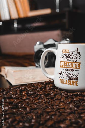 Still life with a cup of coffee, coffee beans, a book and a vintage camera