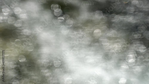 Shiny, flashing circles in flowing water. Abstract silver background with shiny circles.