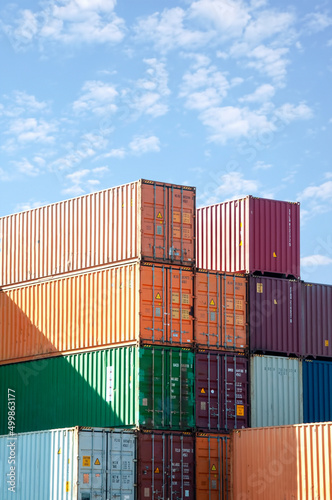 Shipping containers stacked against blue sky photo