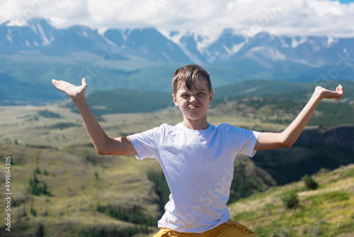 A child funny boy on the Altai mountain background. Concept of tourism, travel, lesure and freedom. Altai mountain, beauty summer evening landcape photo