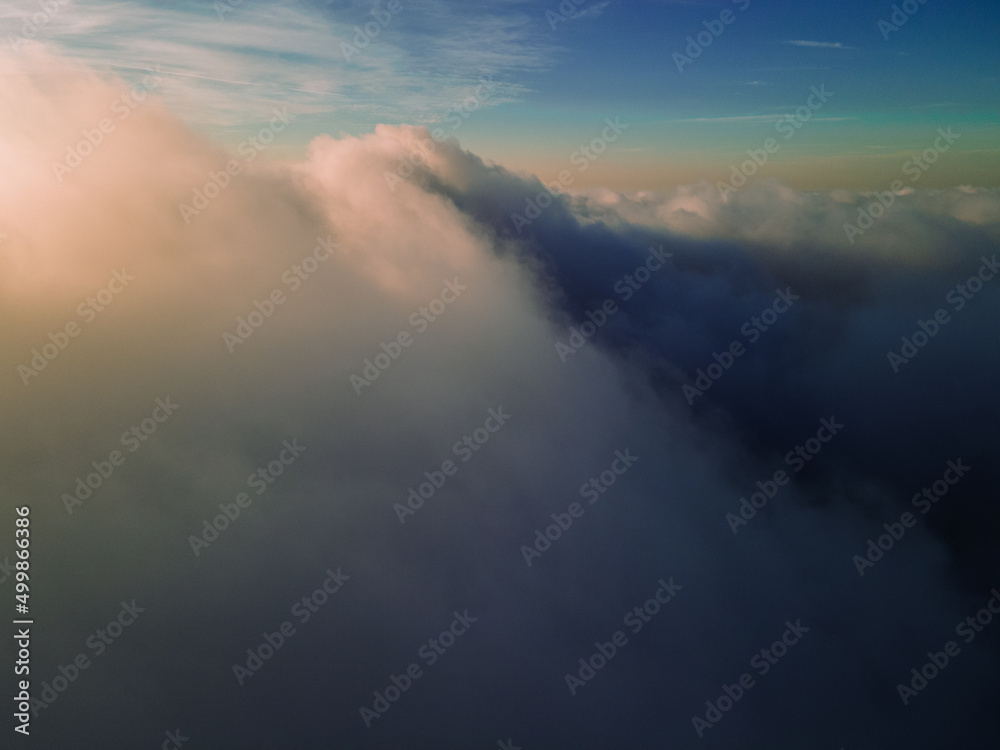 A magical sunset over the clouds. The sun's rays are beautifully reflected from the clouds. Above the sky. Fluffy clouds at sunset thickly covered the sky. shooting at high altitude.