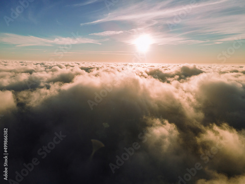 A magical sunset over the clouds. The rays of the sun beautifully pass through the clouds. Above the sky. Fluffy clouds at sunset thickly covered the sky. shooting at high altitude.