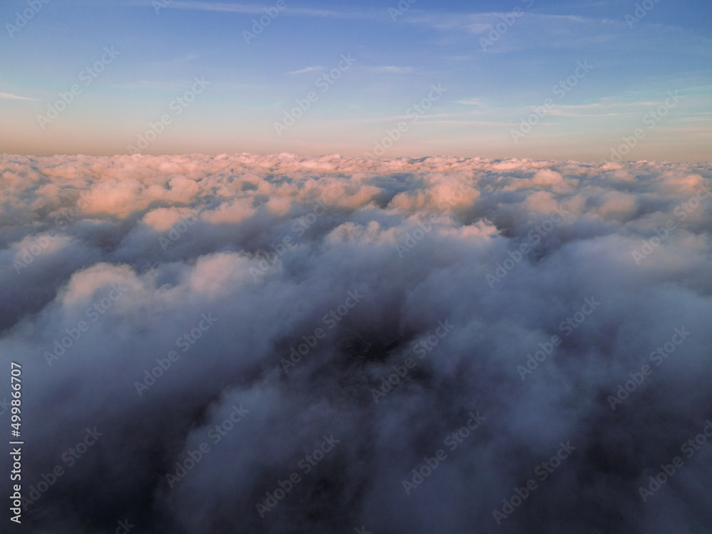 A magical sunset over the clouds. The sun's rays are beautifully reflected from the clouds. Above the sky. Fluffy clouds at sunset thickly covered the sky. shooting at high altitude.