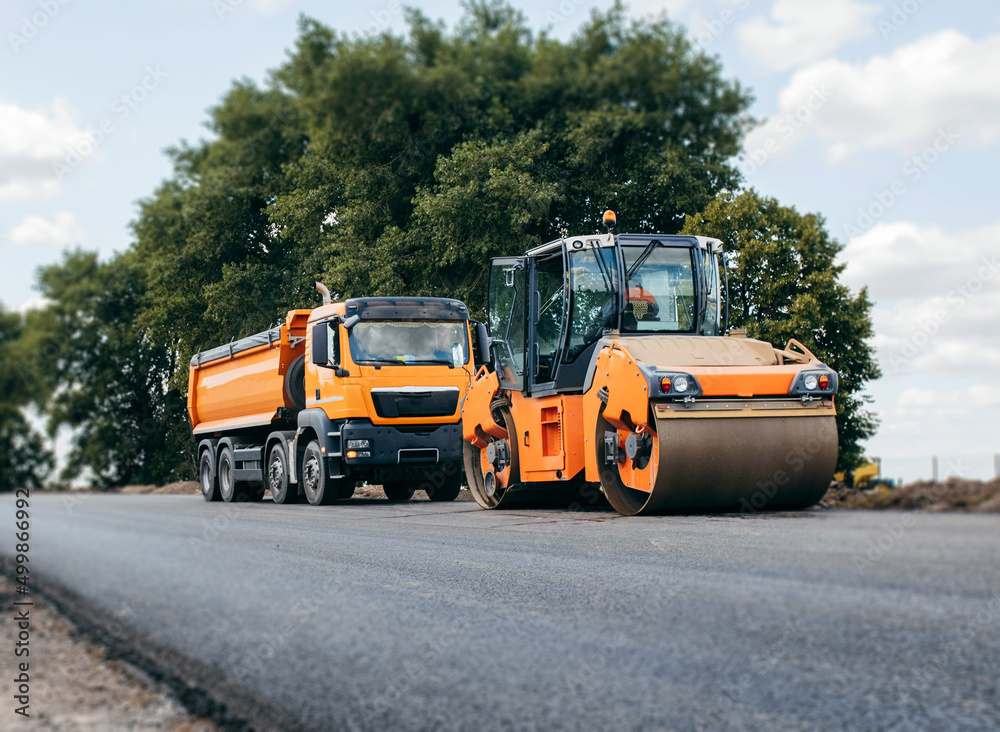 Vibratory asphalt rollers compactor and truckstanding on the side of the road. Road service build a new highway