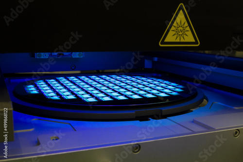 Silicon wafer with chips in UV lighting. Neon. Ultraviolet Lithography.