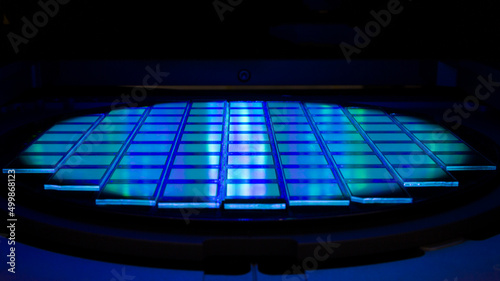 Silicon wafer with chips in UV lighting. Neon. Ultraviolet Lithography.