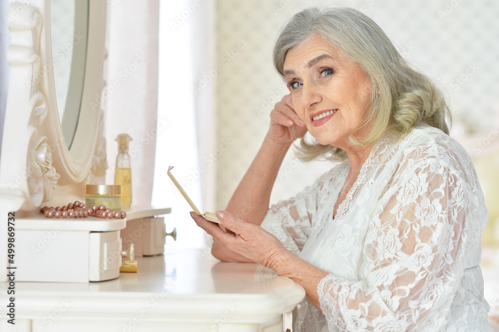 Portrait of happy senior woman sitting near dressing table Portrait of happy senior woman sitting near dressing table