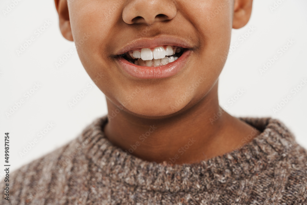 Black preteen boy wearing sweater smiling and looking at camera Black preteen boy wearing sweater smiling and looking at camera